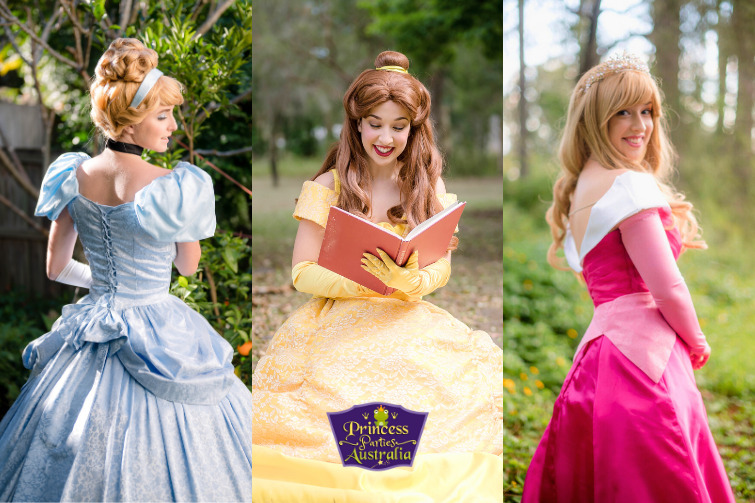 Three women dressed as princesses: the first in a light blue gown with blonde hair, the second in a yellow gown with brown hair, reading a book, and the third in a pink gown with blonde hair. Each princess displays a cheerful expression.