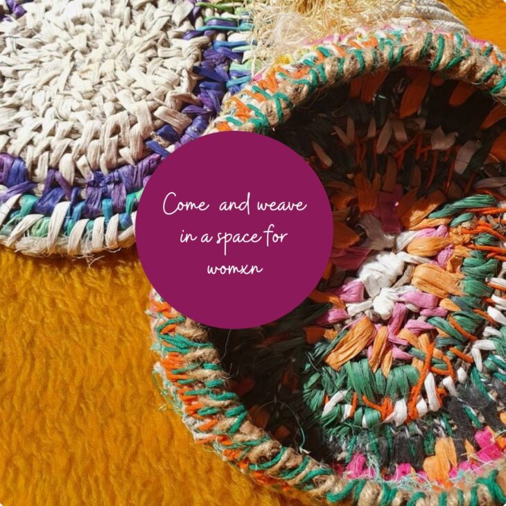 Colorful woven baskets displayed on a textured surface, featuring a mix of vibrant colors and intricate patterns. A circular purple overlay contains the text inviting women to gather in a shared space.